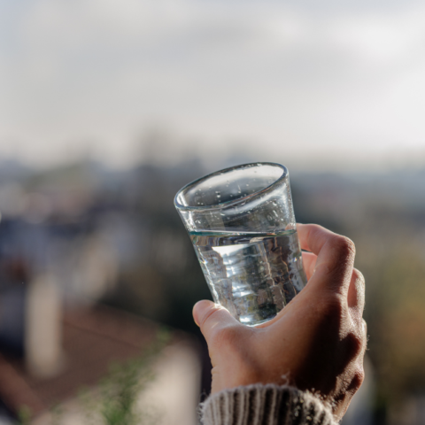 Une jeune femme de profil tenant un verre d'eau